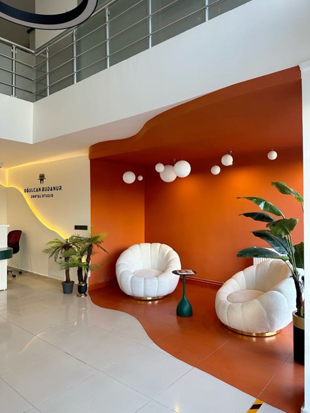 Branded dental studio reception with a bold orange feature wall