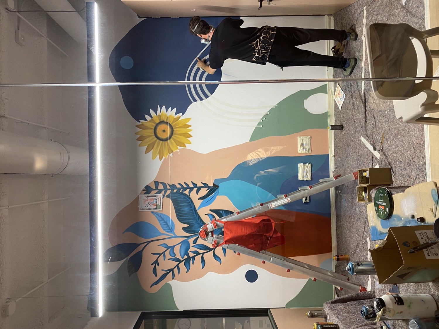 Mural in progress, working from a ladder