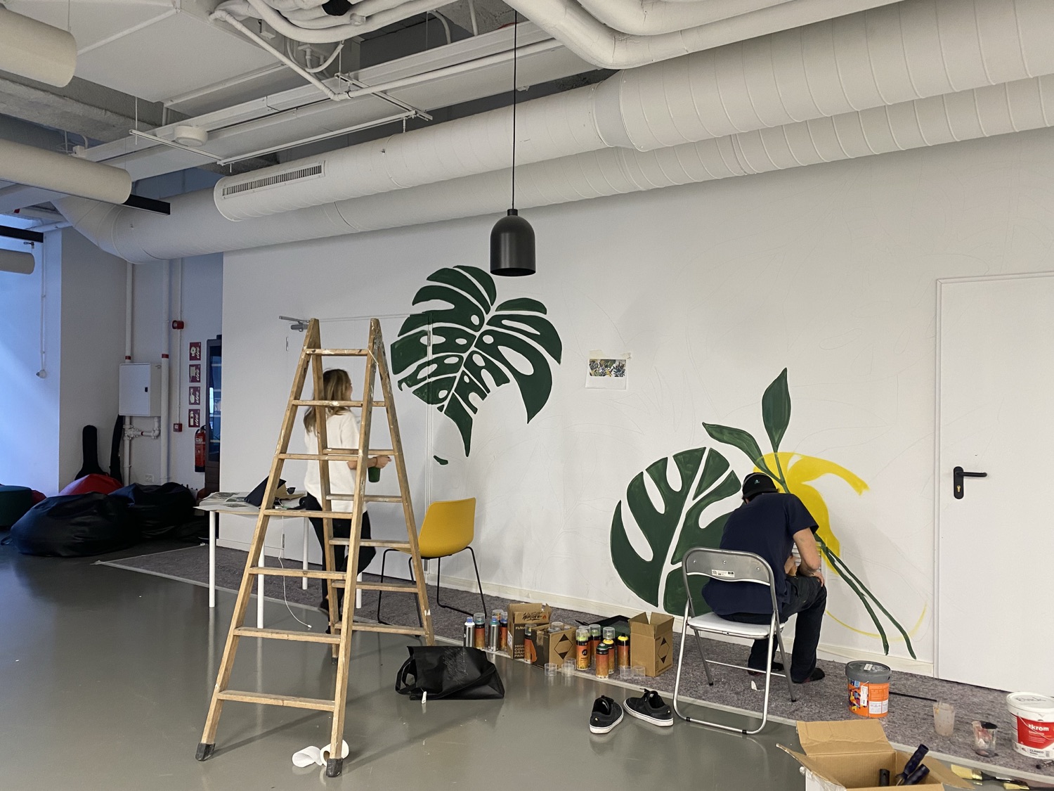Painting a large monstera leaf mural in the studio